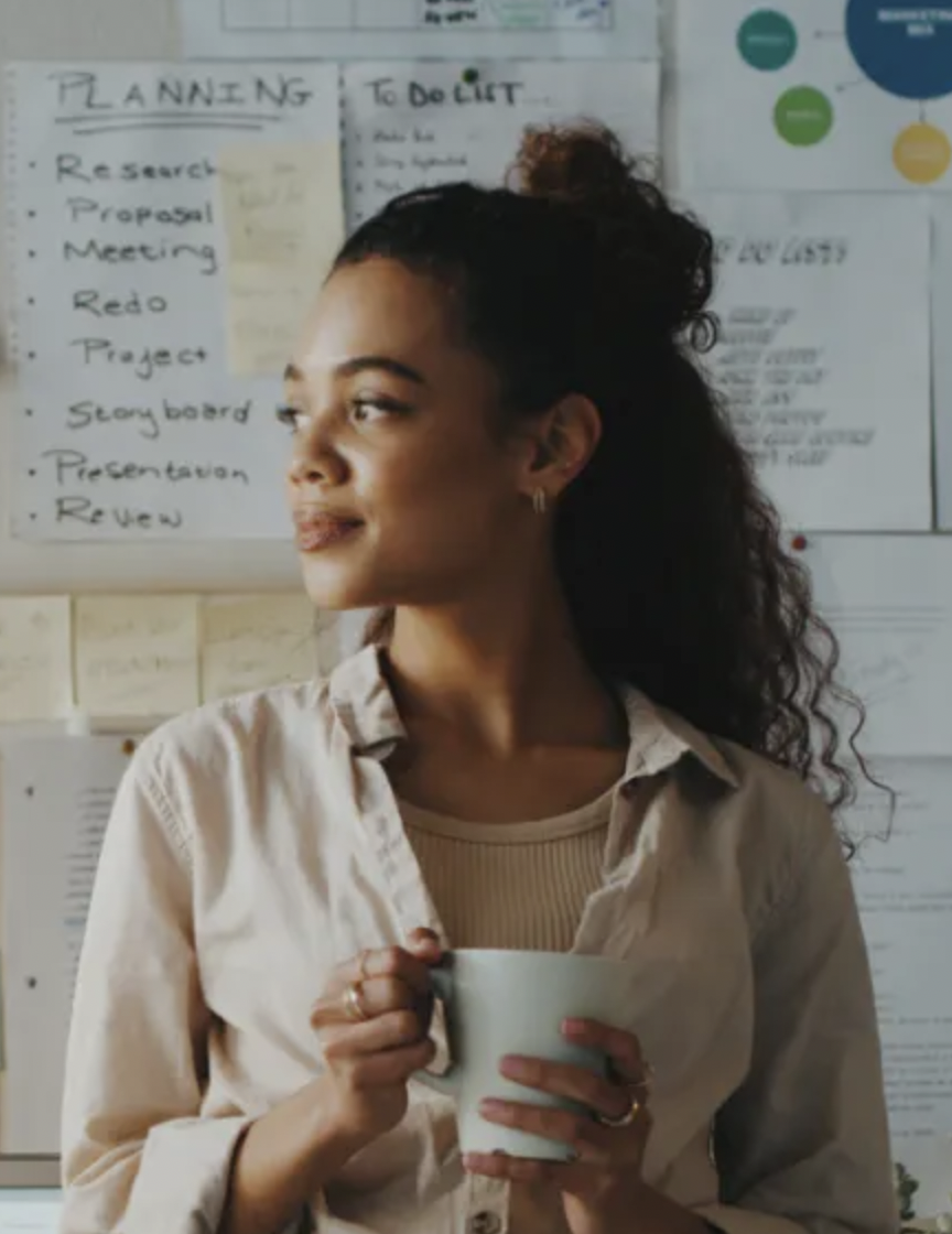 Woman drinks coffee while looking off to her right