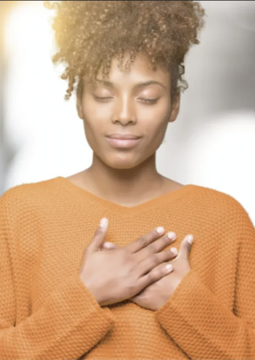 Woman holds hands over heart