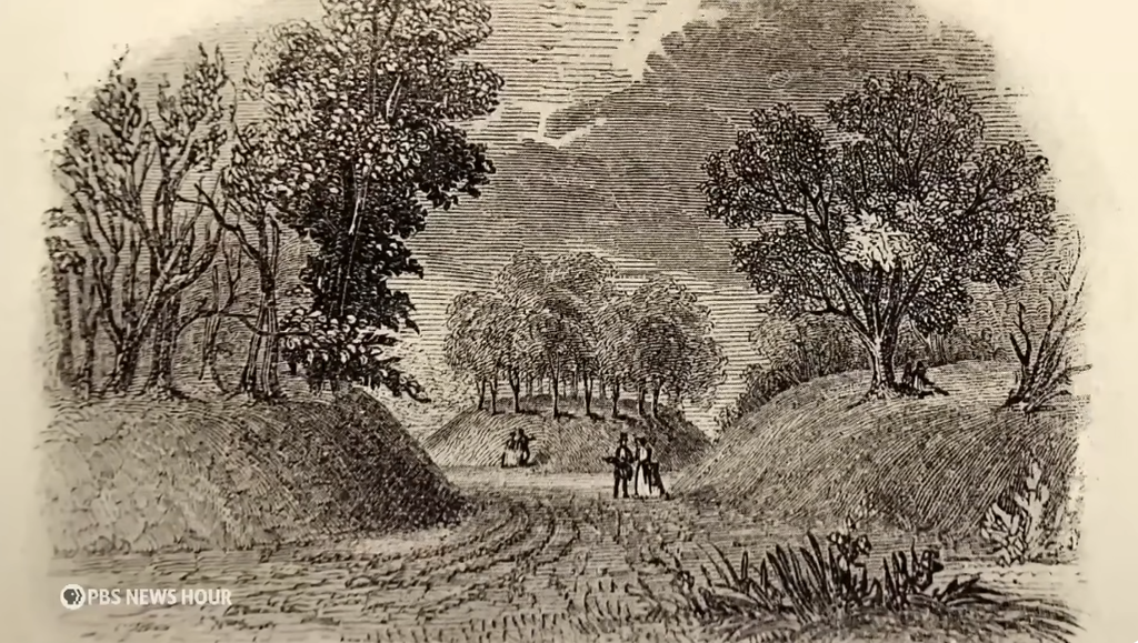 A 19th-century illustration of people walking between the raised earthen walls of a Hopewell earthwork, surrounded by trees, showing how the site looked before much of it was altered by later development.