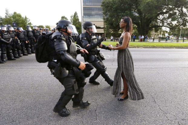 Lone activist Ieshia Evans stands her ground while offering her hands for arrest as she is charged by riot police during a protest against police brutality outside the Baton Rouge Police Department in Louisiana, July 2016